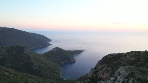 Flight over the mountains Aerial top sea view Green rocks surrounded by the blue Stock Footage 228465131