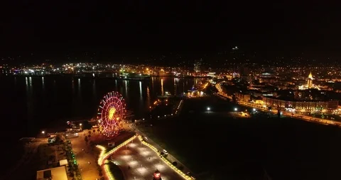 Flight over a night city over a ferris wheel in georgia Stock Footage 129561441
