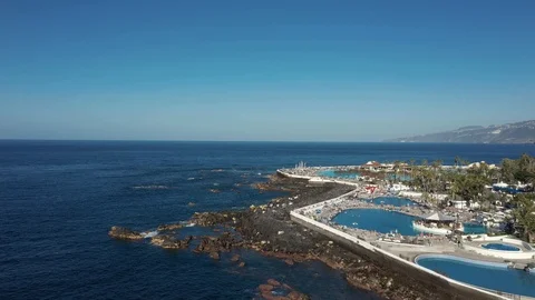 Flight over ocean beach with hotel pools and relaxing people Stock Footage 101961156