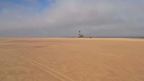 Flight over the oceanfront lighthouse at Sandwich Harbour Stock Footage 157922867
