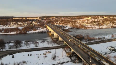 Flight over the Oka River, a road bridge traffic in winter, sunset over the city Stock Footage 254068459
