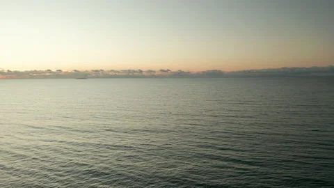 Flight over open sea, ocean. Flying over water toward horizon at sunrise Stock Footage 142060530