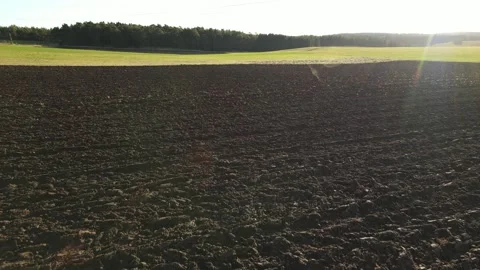 Flight over a plowed arable field with soil on a sunny day in winter Stock Footage 251822772