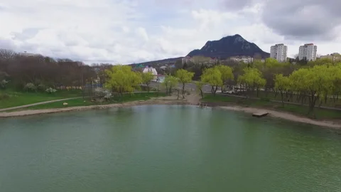 Flight over the pond overlooking the mountain and town Stock Footage 153022463