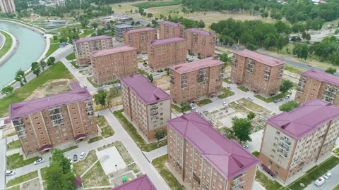 A flight over red high-rise buildings. Vechicles on road. Red rooftop Stock Footage 154898683