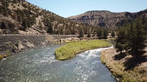 Flight over remote high desert flyfishing stream canyon Stock Footage 95878051