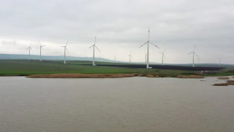 Flight over the reservoir against the backdrop of windmills. Stock Footage 229767472