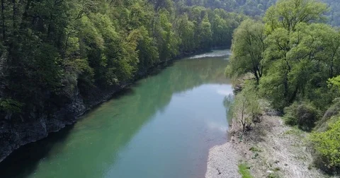 Flight over a river surrounded by a forest Stockbeeldmateriaal 75603539