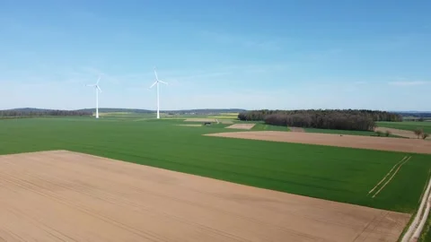 Flight over the road and the field towards the wind generator 動画素材 154370833