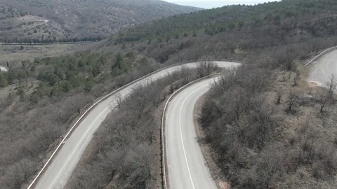 Flight over the road in the mountains on which the car moves Stock Footage 106451296
