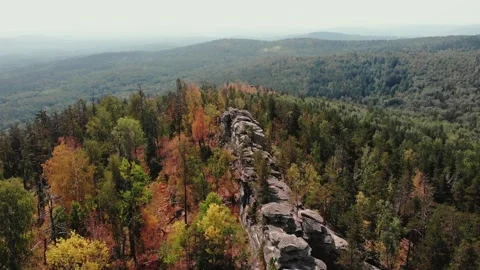 Flight over the rocks in the autumn forest. Drone flight from above. Golden Stockbeeldmateriaal 243258900