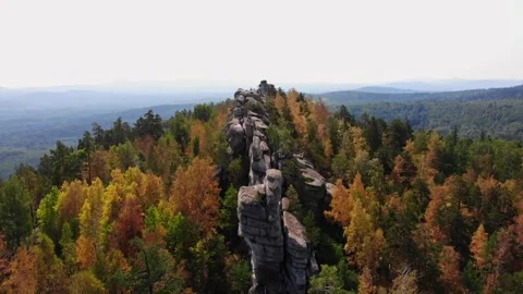 Flight over the rocks in the autumn forest. Drone flight from above. Red yellow Stockbeeldmateriaal 243258964