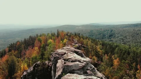 Flight over the rocks in the autumn forest. Drone flight from above. Red yellow Stockbeeldmateriaal 243258988