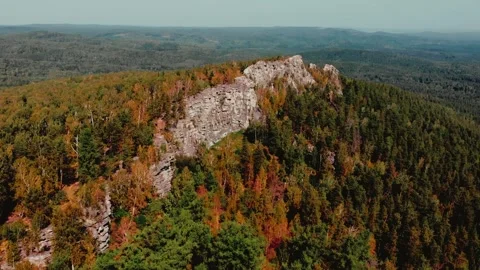 Flight over the rocks in the autumn forest. Drone flight from above. Red yellow Stockbeeldmateriaal 243259036