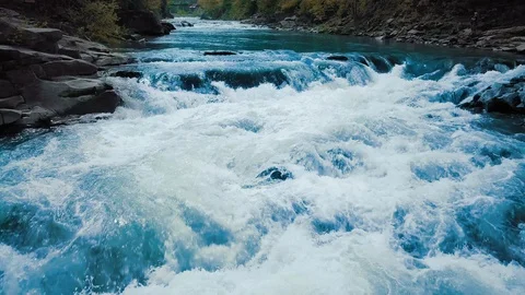 Flight over the rushing mountain river and waterfall, blue in the middle of the Video stock 92125277