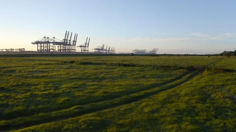 Flight over salt marsh and sea wall to Felixstowe Container Port Video stock 110899128