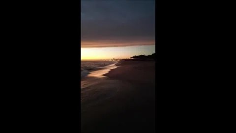 A flight over the sandy beach of the Atlantic at sunset Stock Footage 299142305