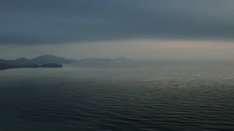 Flight over the sea surface in the predawn haze to the mountain headlands crashi Stock Footage 151151549