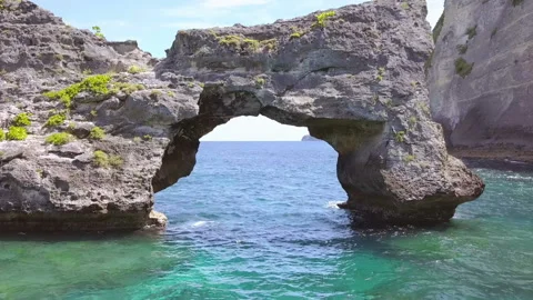 Flight over the Sea Surface through a Stone Arch. Aerial View Stock Footage 106456589
