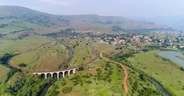 Flight over seven arch rail bridge next to trout ponds in Waterval Boven Stock Footage 85953948