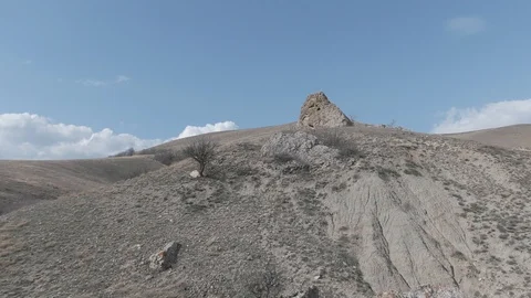 Flight over the slope of the mountain against the blue sky with white clouds Stock Footage 119564783