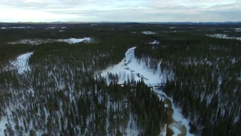 Flight over small frozen stream Petikan in Swedish Lapland Stock Footage 155554577