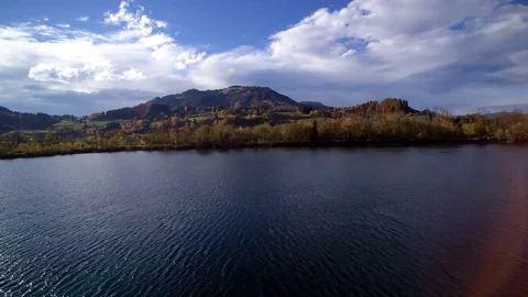 Flight over a small lake in front of a mountain panorama Stock Footage 97905708