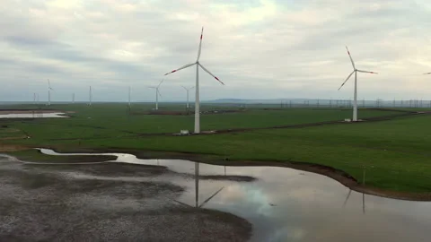 A flight over a small lake which reflects the windmills set around. Stock Footage 229768773