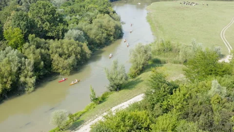 Flight over a small river with a couple of kayaks racing  on a sunny day Видео 137971398