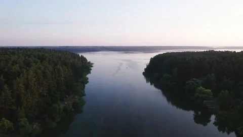 Flight over small river to the wide water on sunrise Stock Footage 205825878