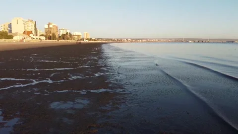 Flight over the small waves of the patagonian sea in Puerto Madryn at sunrise Stock Footage 168716765