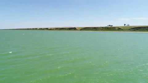 Flight over the smooth surface of the water of an artificial reservoir Stock Footage 153341324