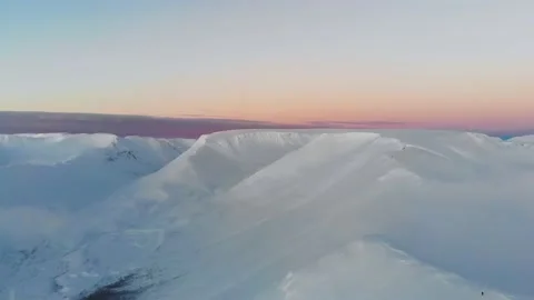 Flight over snow-capped mountains at sunset. Aerial view. Colorful winter sunset Video stock 147224846