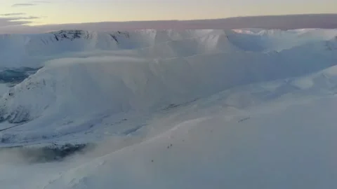 Flight over snow-capped mountains at sunset. Aerial view. Colorful winter sunset Video stock 152588049