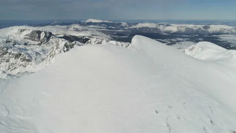 Flight over the snow-capped peaks of the mountains of Durmitor Stock Footage 102776166