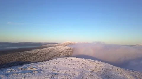 Flight over a snow-covered mountain illuminated by the rays of the sun Stock-Footage 143347101