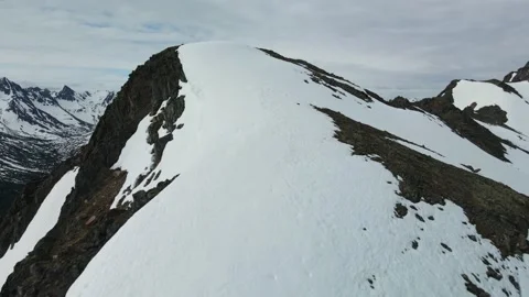 Flight over snow covered ridge to Valley below, Drone, Aerial Stock Footage 169553563