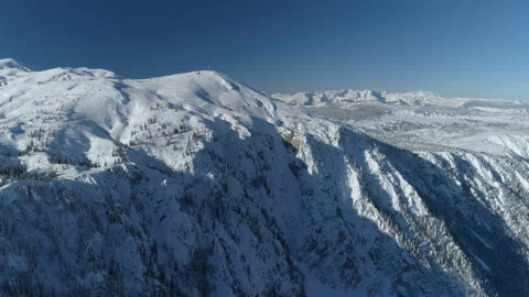 Flight over the snow-covered spruce forest with mountains in the background Stock Footage 147161248