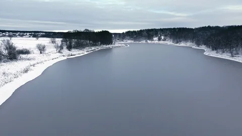 Flight over the snow forest and the frozen lake in the first snow Stock Footage 87457092