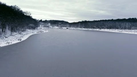 Flight over the snow forest and the frozen lake in the first snow Stock Footage 87550395