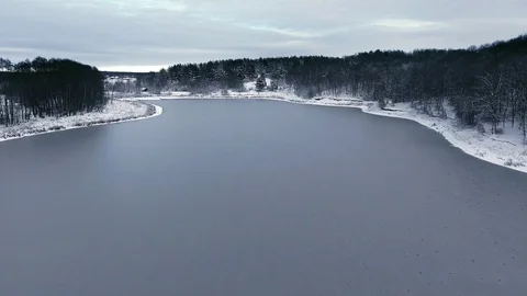 Flight over the snow forest and the frozen lake in the first snow Stock Footage 88204991