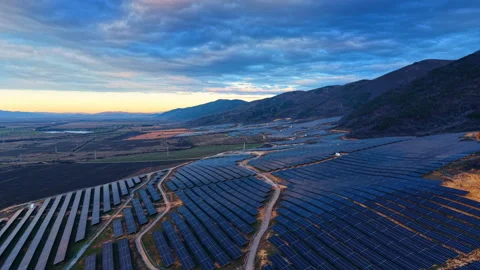 Flight over solar panel field near the mountains. Dark cloudscape covers the sky Stock Footage 334339219