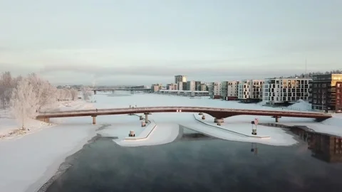 Flight over a steaming river and pedestrian bridge. Stock Footage 130781039