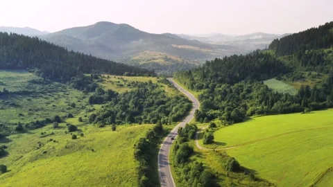 Flight over the summer mountains with mountain road serpentine Stock Footage 158540040