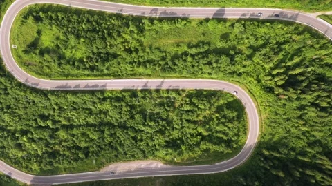 Flight over the summer mountains with mountain road serpentine Stock Footage 158540093