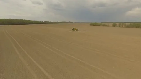 Flight over the tractor on a spring field  Vídeo Stock 69125489