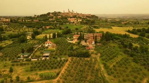 Flight over Tuscan fields with medieval village in the background Video stock 319964031