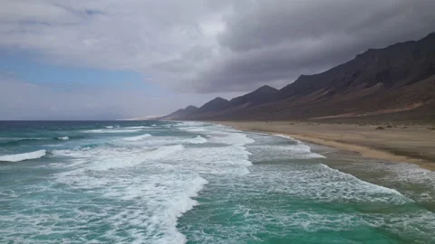 Flight over waves splash on desert beach Stock Footage 194920687