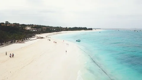 Flight over wide paradise beach with white sand and azure ocean on cloudy day Stock Footage 91798928