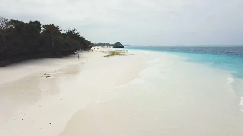 Flight over wide paradise beach with white sand and azure ocean on cloudy day Stock Footage 91801565